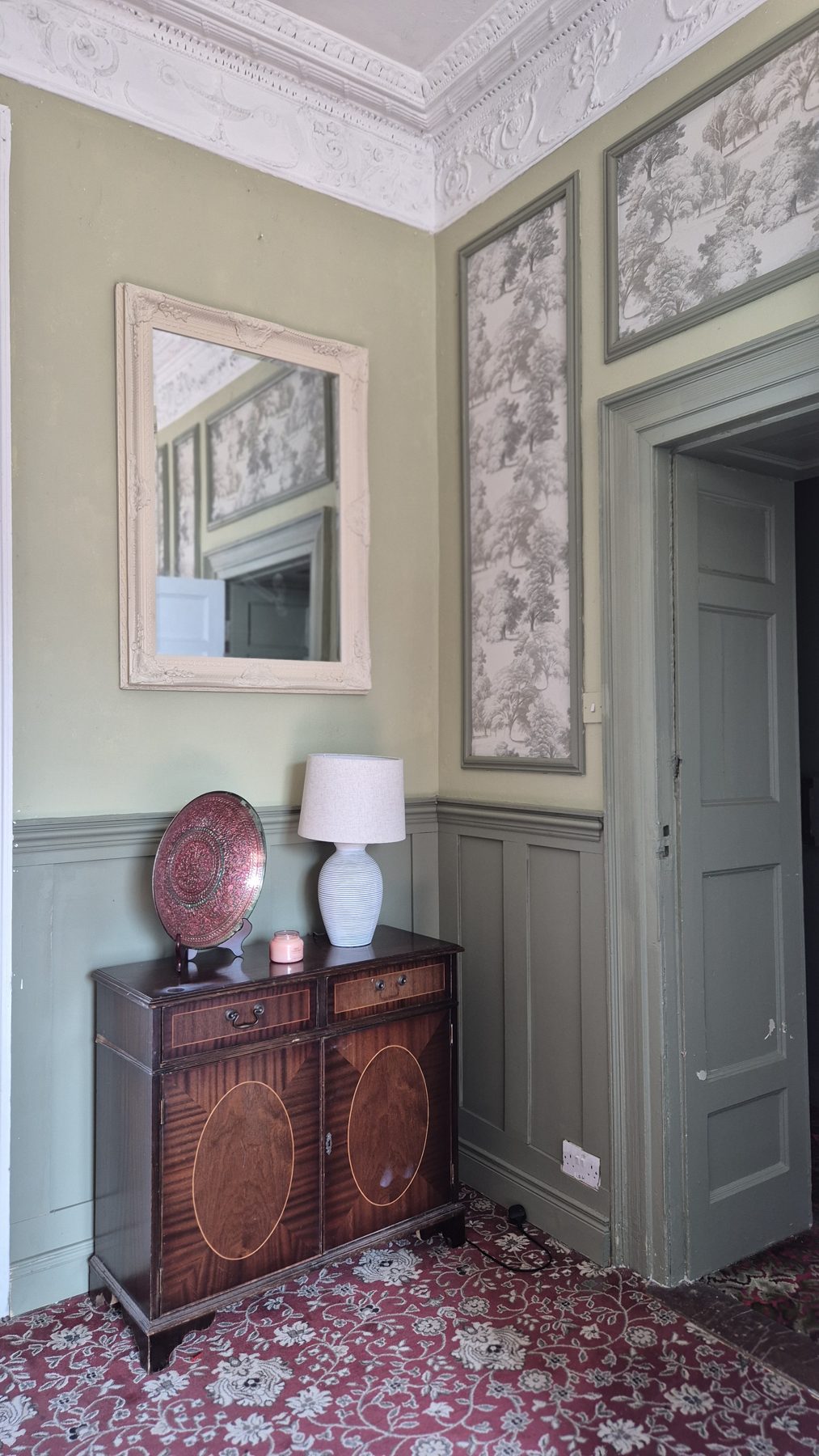 Reception room at Kyle Park with a painted green door and antique furnishings