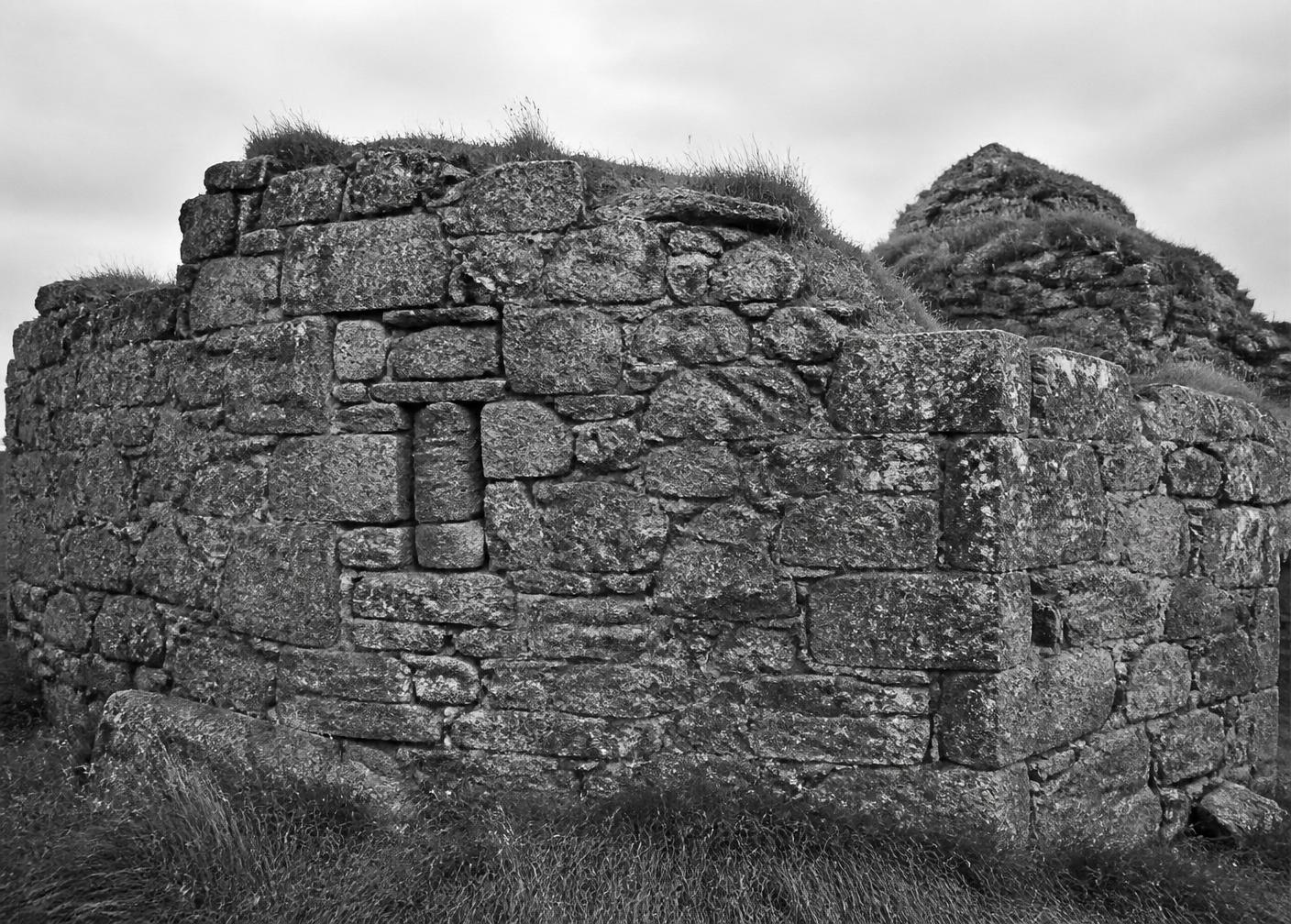 Black and white photograph of the surviving granite footing of an Irish castle